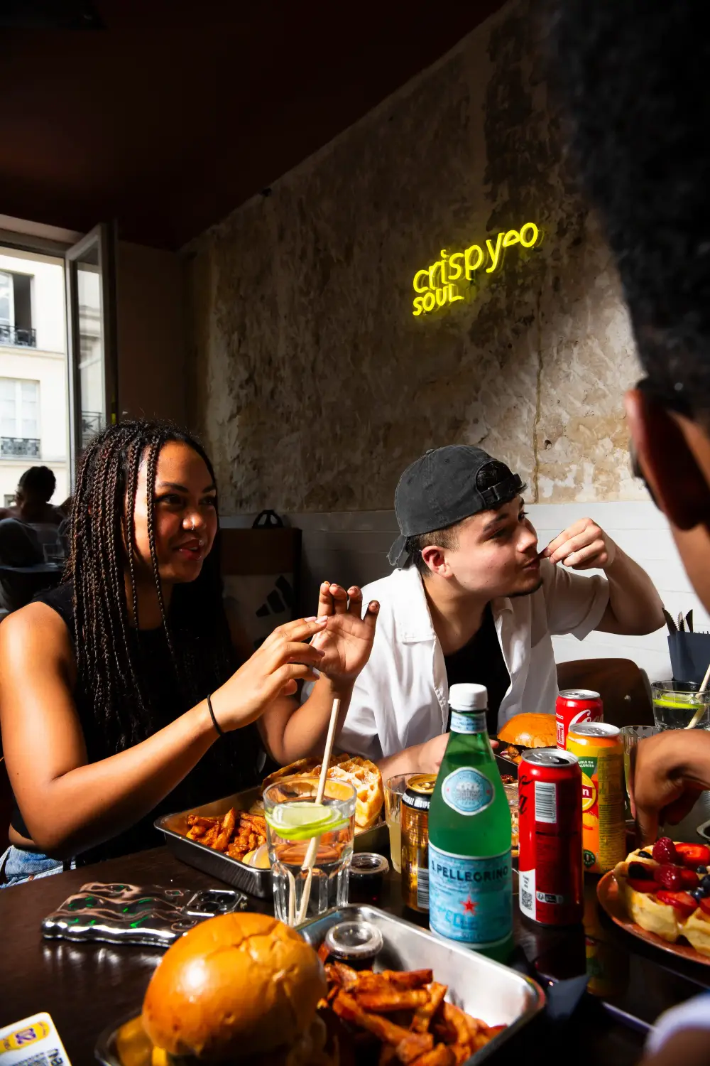 Groupe d'amis autour d'une table partageant une commande groupe poulet CRISPY SOUL