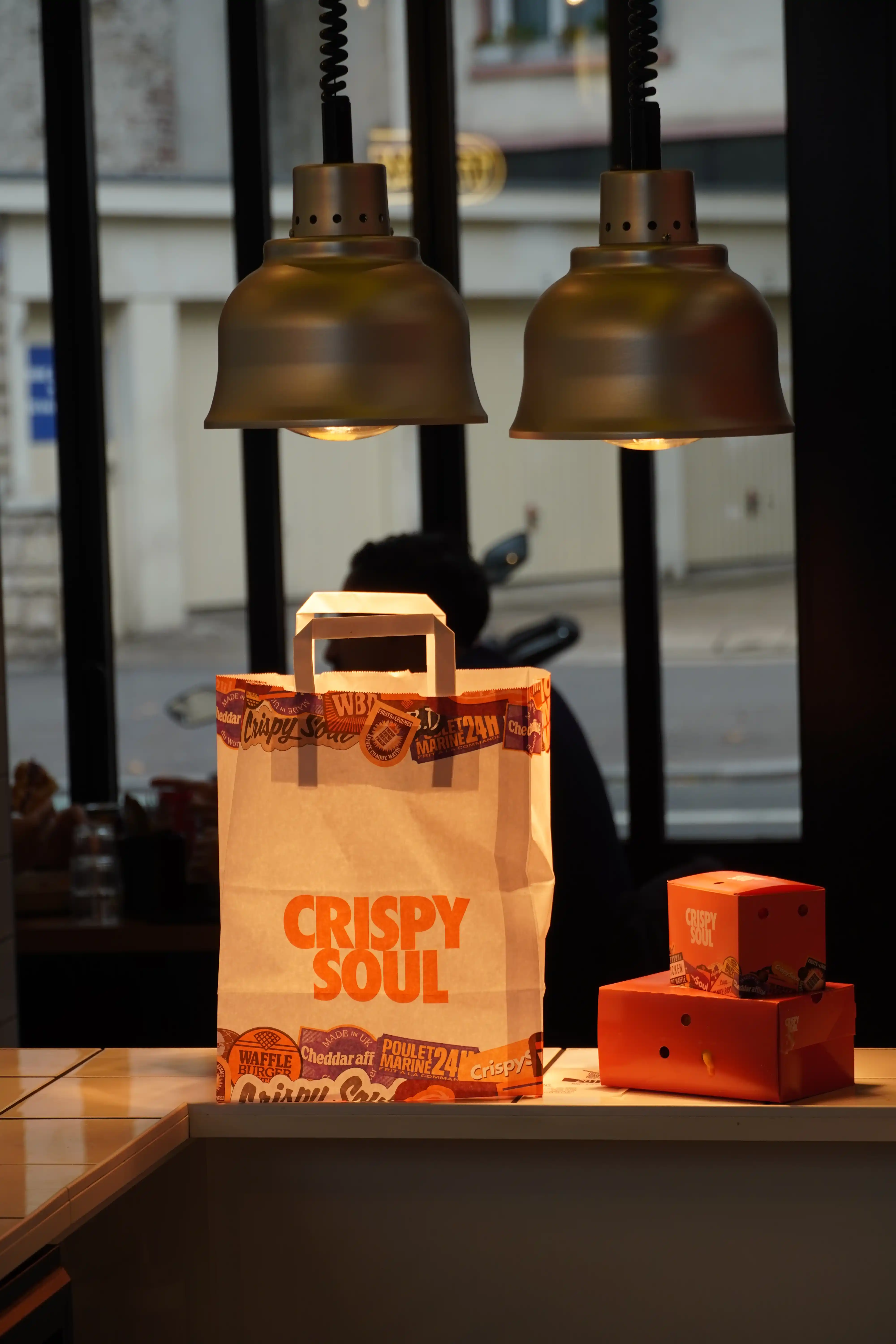 Comptoir CRISPY SOUL avec sac de commande à emporter sous les lampes
